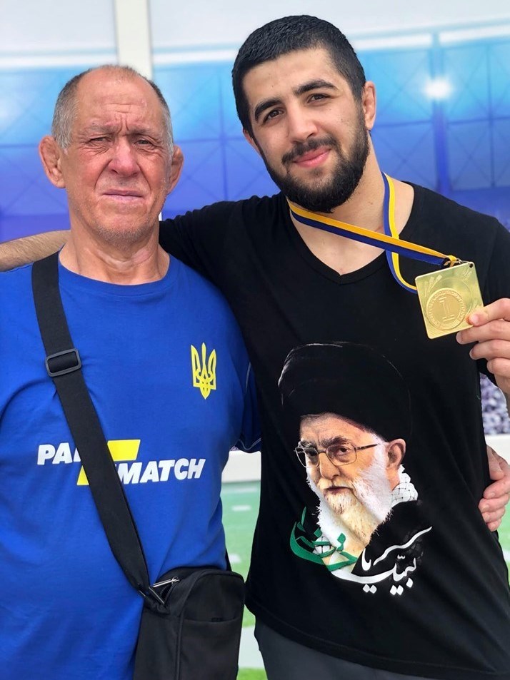 حضور کشتی‌گیر اوکراینی بر سکوی قهرمانی با پیراهنی منقش به تصویر رهبر انقلاب
